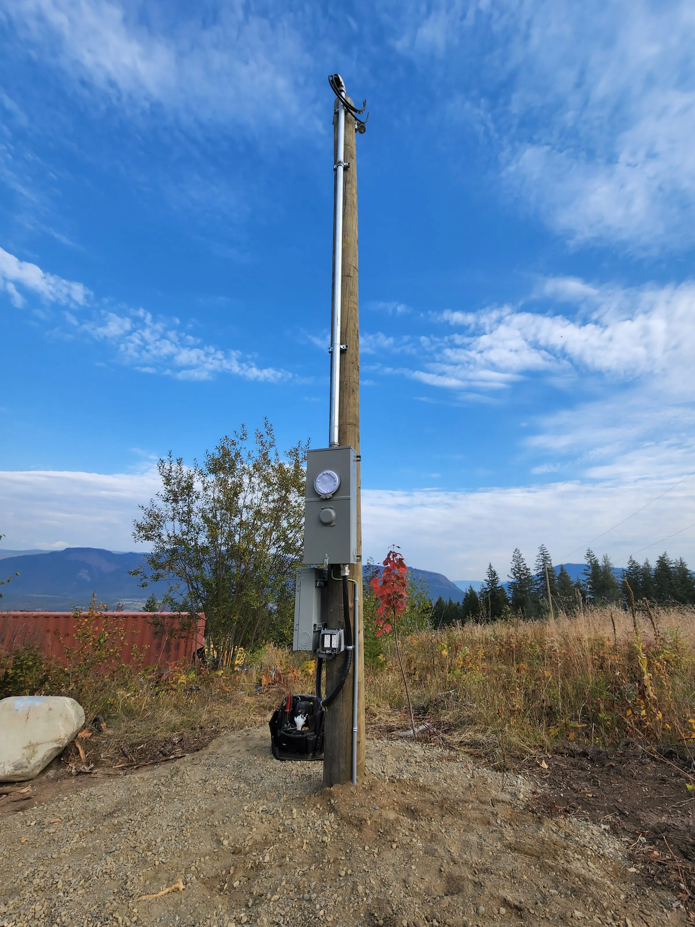 Pole-mounted meter, disconnect, and weatherproof receptacle for a rural power service