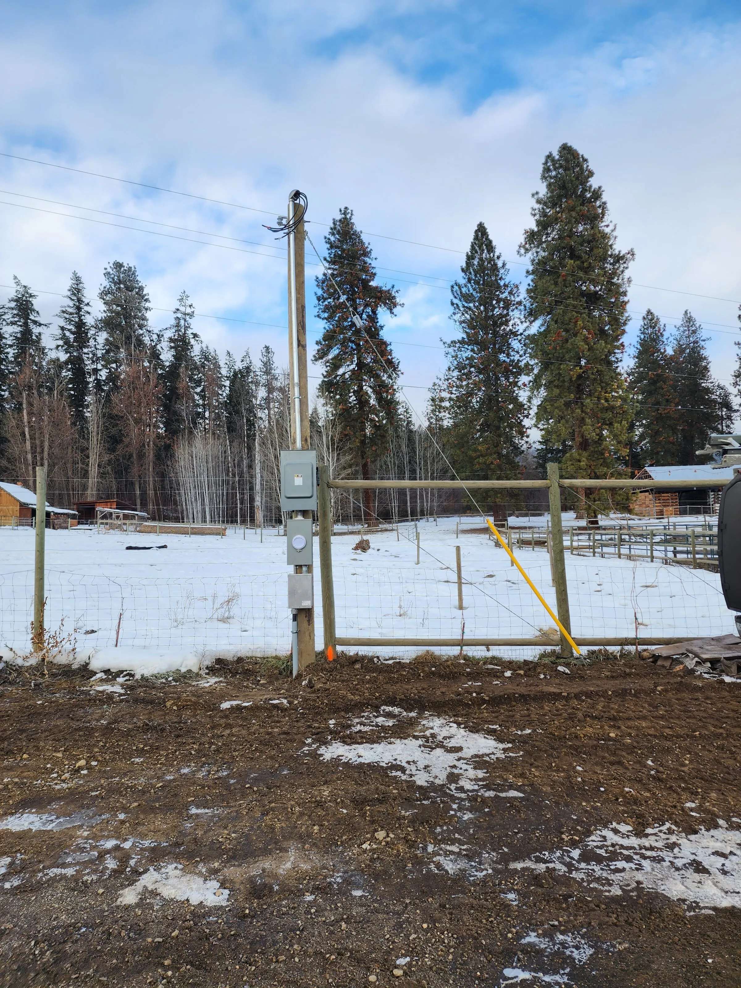 Metered electrical service installed on a farm fence line in winter
