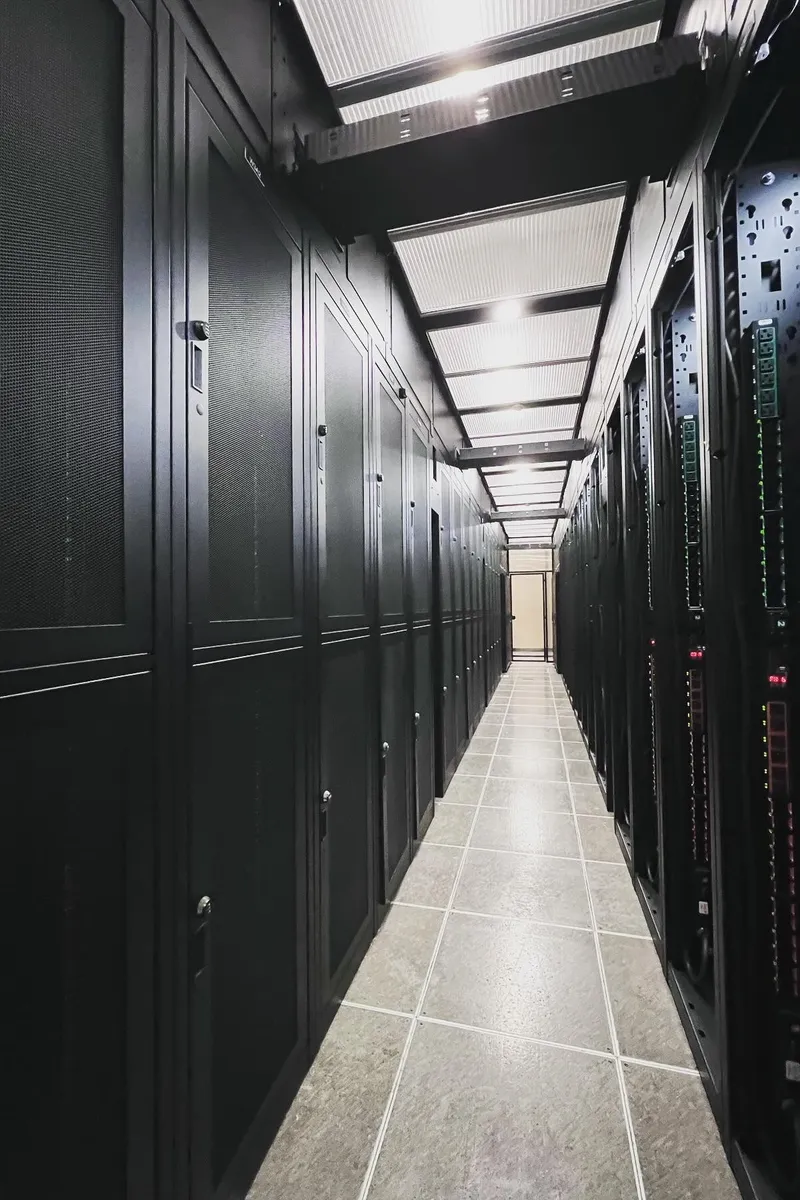 Contained aisle of server rack cabinets inside a data center managed by Dayton Power & Controls