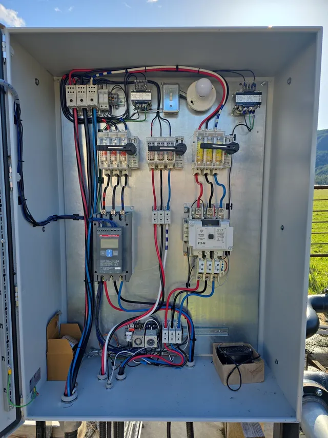 Well-head control box and submersible pump casing on the gravel pad