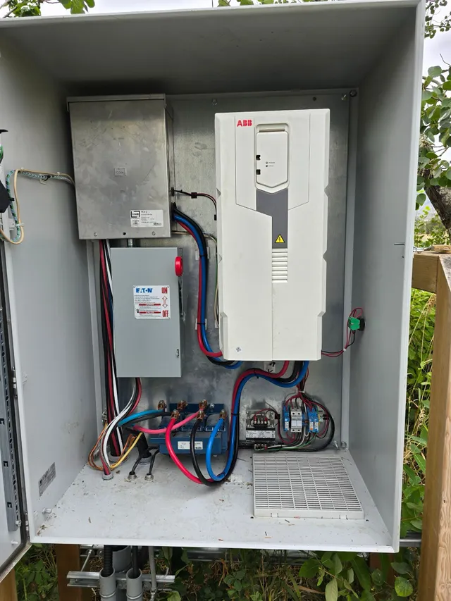 Four variable frequency drives conduited in a row on the pump house wall