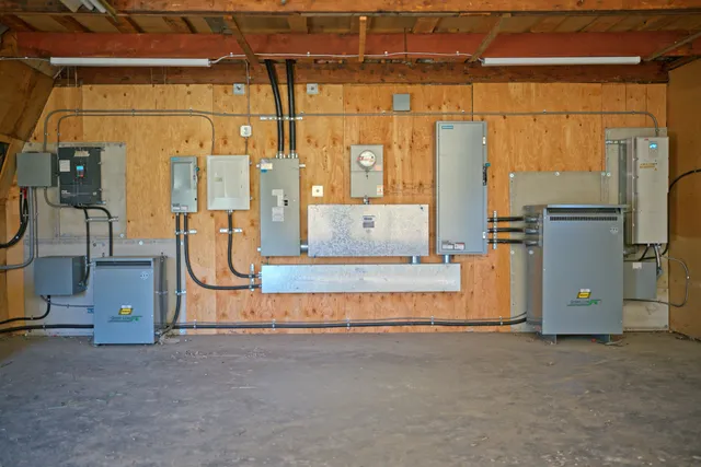 Power distribution wall with panels, transformers and metering in the pump house