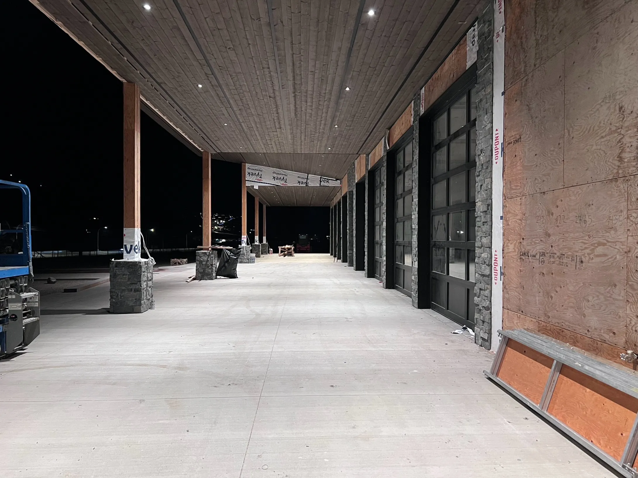 Recessed canopy lighting glowing at night outside a commercial building under construction