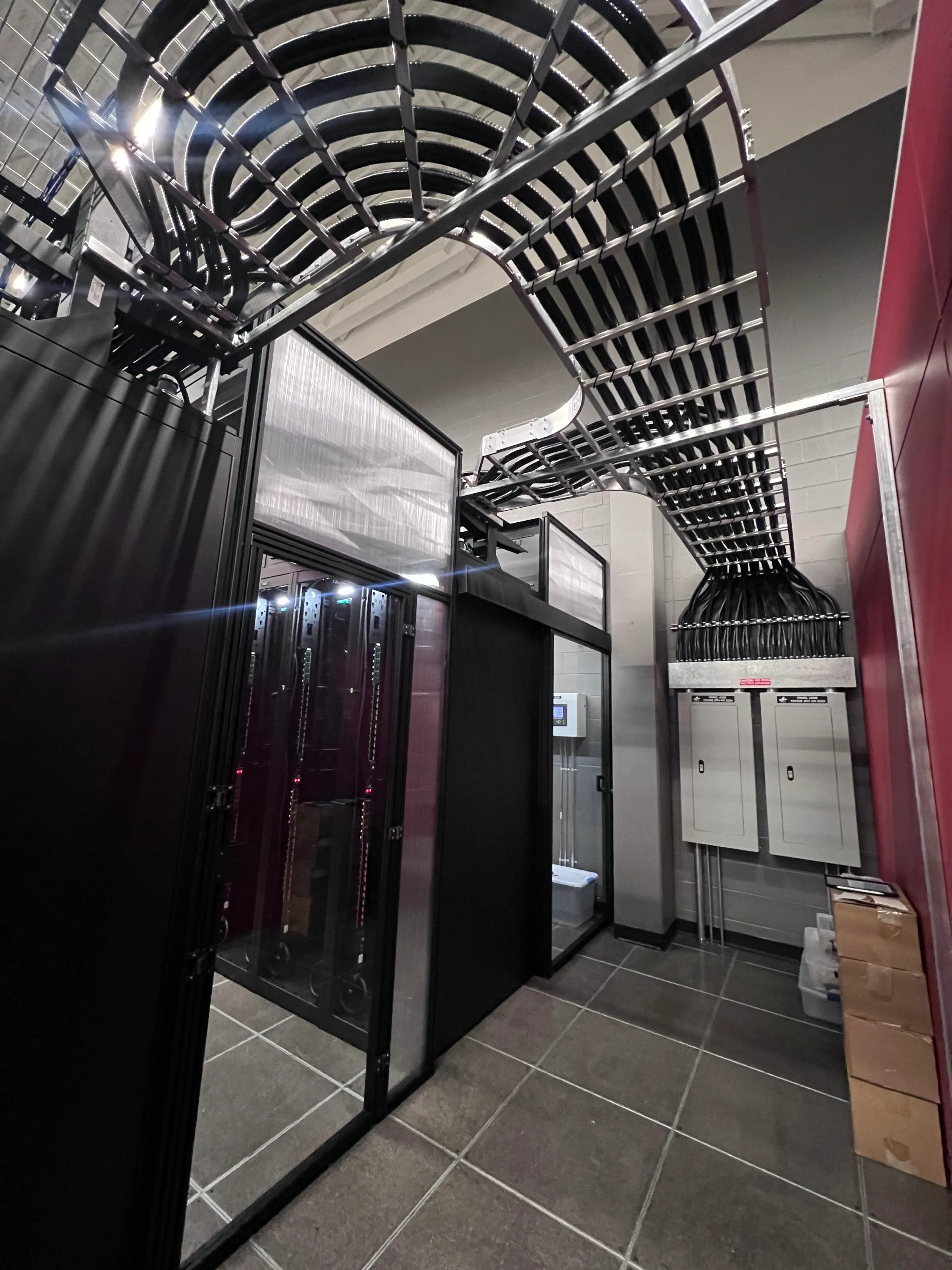 Overhead cable tray fanning bundled cabling into power panels in a data center built by Dayton Power & Controls