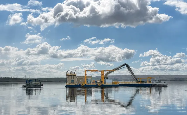 The completed E-House riding Suncor's tailings dredge out on the pond