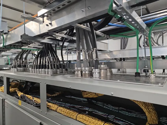 Cable glands and tray drops feeding the PLC lineup from overhead