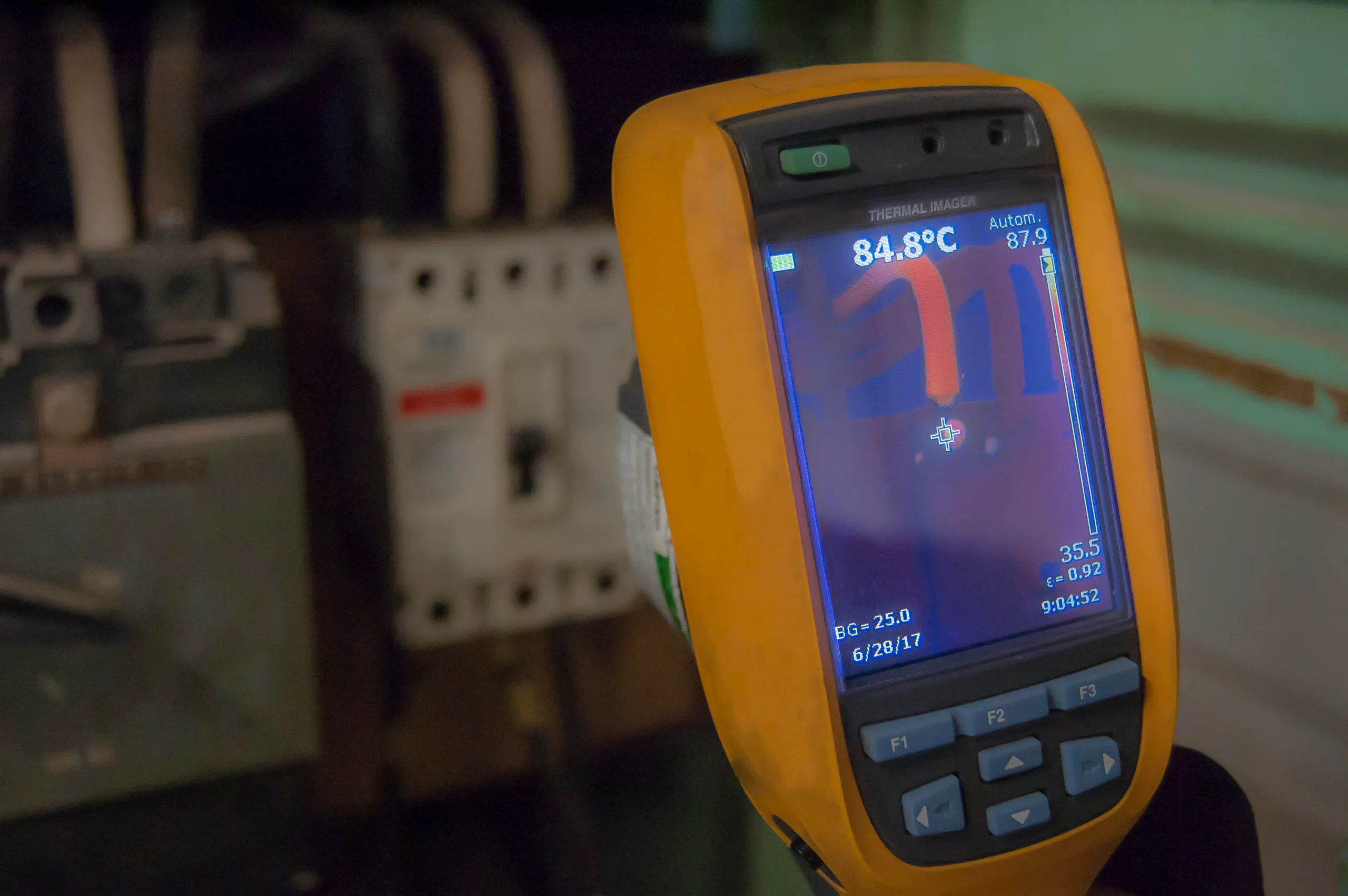 Thermal imaging camera scanning circuit breakers during a preventative electrical inspection